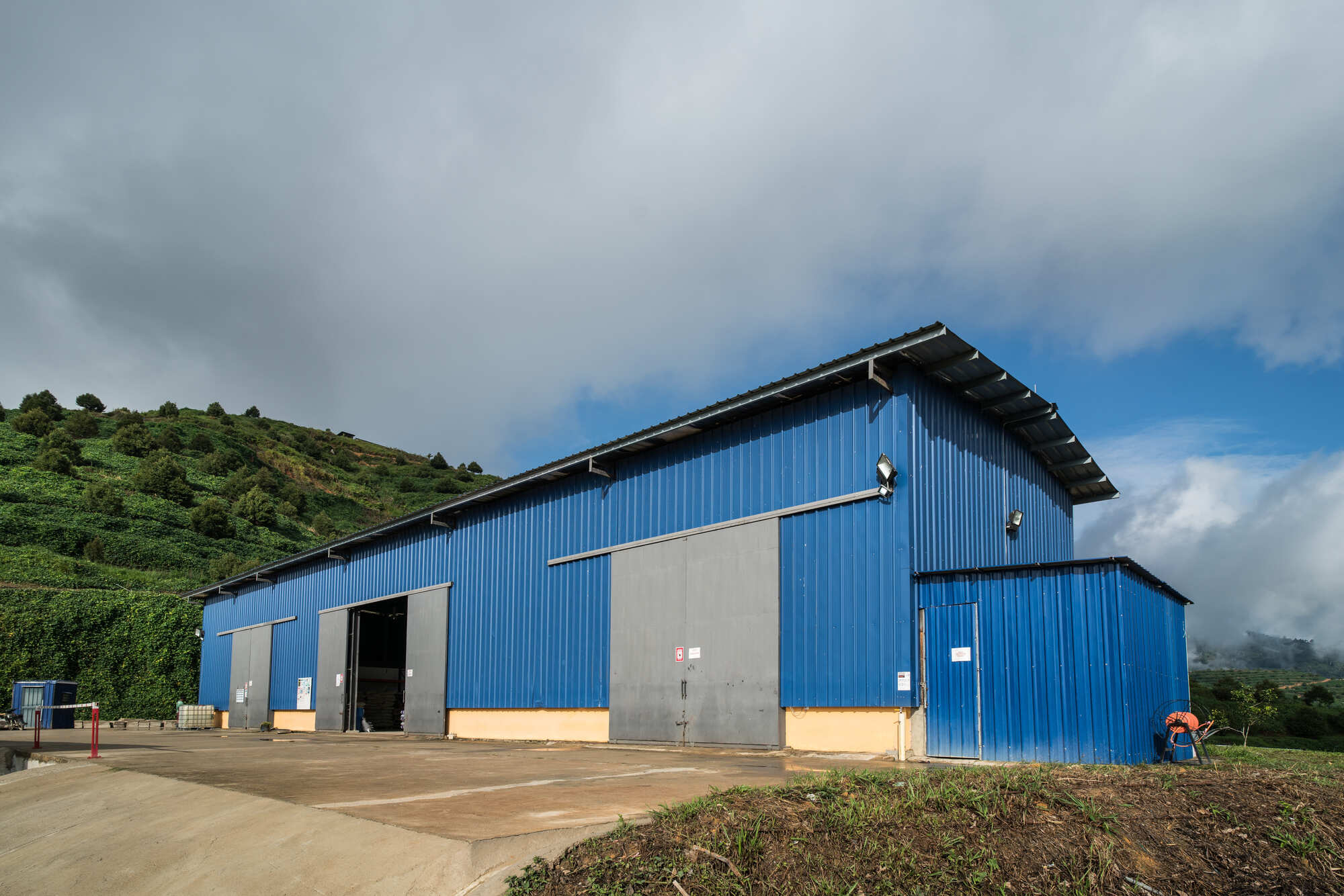 Blue industrial building with mountains in the background